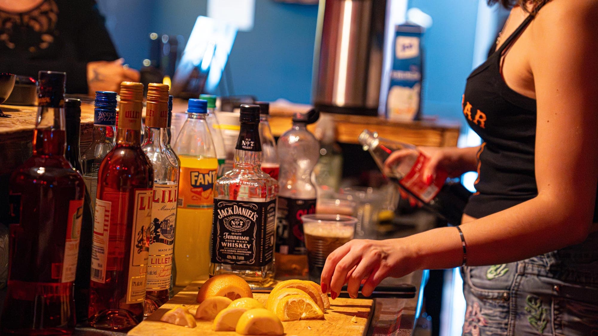 Flaschen und Zitrusfrüchte bei der Drinkvorbereitung